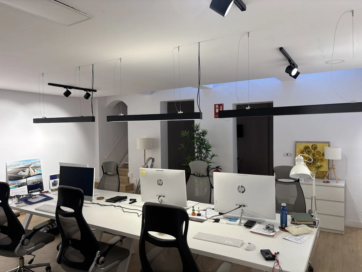 Oficina de Carlos en Sevilla, puestos de trabajo con nueva iluminación lineal y focos